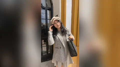 Stylish woman in a grey plaid blazer and beige beret posing outdoors with a chic, sophisticated mood.