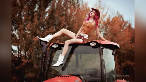 Stylish woman in a brown corset and cowboy hat sitting on a red tractor in an autumn forest setting.