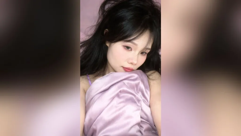 lingzi — lingzi poses in a purple satin slip with her dark hair falling over her shoulders.