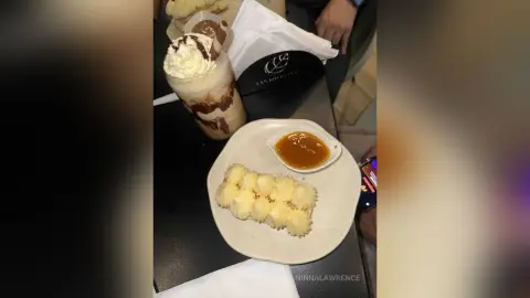 Delicious chocolate milkshake with whipped cream and buttery cookies served on a cafe table.