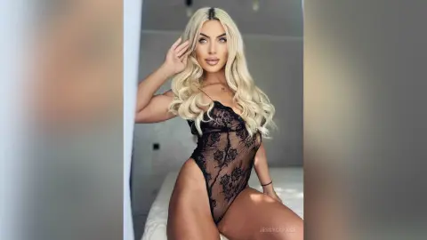 JessycaPage poses in a black lace bodysuit, showing off her long blonde hair and curvy body.