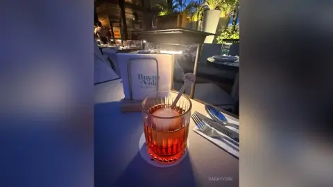 Refreshing amber cocktail in a crystal glass served on a restaurant table during a cozy evening dinner.