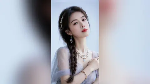 liyufei poses with a long braid and silver jewelry, wearing a sheer light blue mesh top.