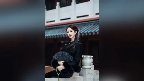 Elegant woman in traditional black Hanfu holding a folding fan in a serene ancient Chinese temple courtyard.