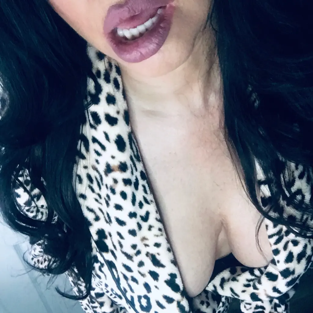 JeanetteFox shows off her cleavage and long dark hair while wearing a white open robe.