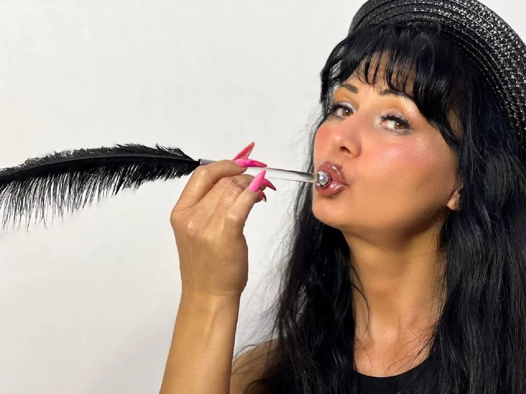MelissaWonders blows through a clear bubble wand with long pink nails and black hair.