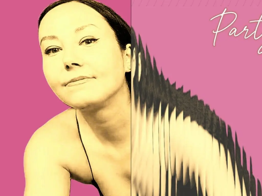 Young woman with long dark hair wearing pink floral lace lingerie while lying on a blue studio background.