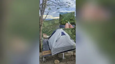 RossiNoleen lies on a bed or mat outside a tent overlooking a lush, green mountain valley.