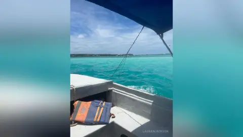 View from a boat looking out over turquoise tropical ocean waters under a clear blue sky.
