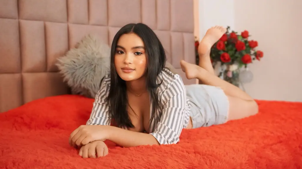 MiaaPalmer with long dark hair wearing a red satin robe while looking at the camera.