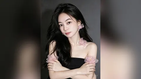 CelesteQi — CelesteQi poses with long black hair and pink floral accessories in a black strapless top.