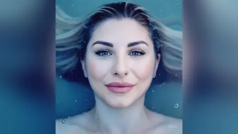 Smiling blonde woman floating underwater in a serene blue ocean setting.
