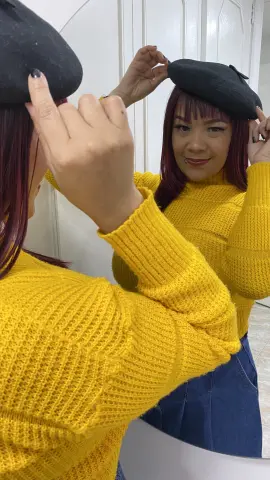 Smiling woman in a yellow ribbed sweater and black beret posing in a mirror for a cozy autumn look.