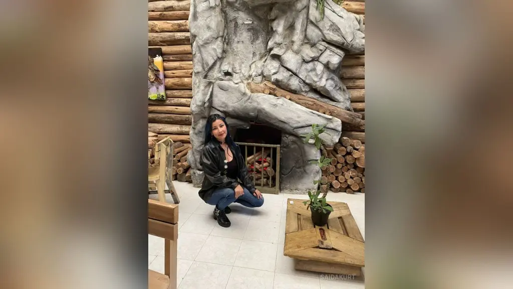 Saidakurt — Saidakurt sits on the floor in a black leather jacket and blue jeans in front of a large rock fireplace.