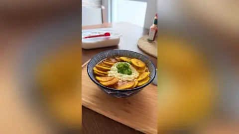 Delicious sliced plantains served in a blue patterned bowl on a wooden tray for a tropical snack.