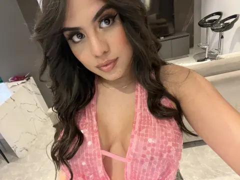 Leialeen — Young woman in a pink sequin halter top posing in a modern living room with a confident mood.