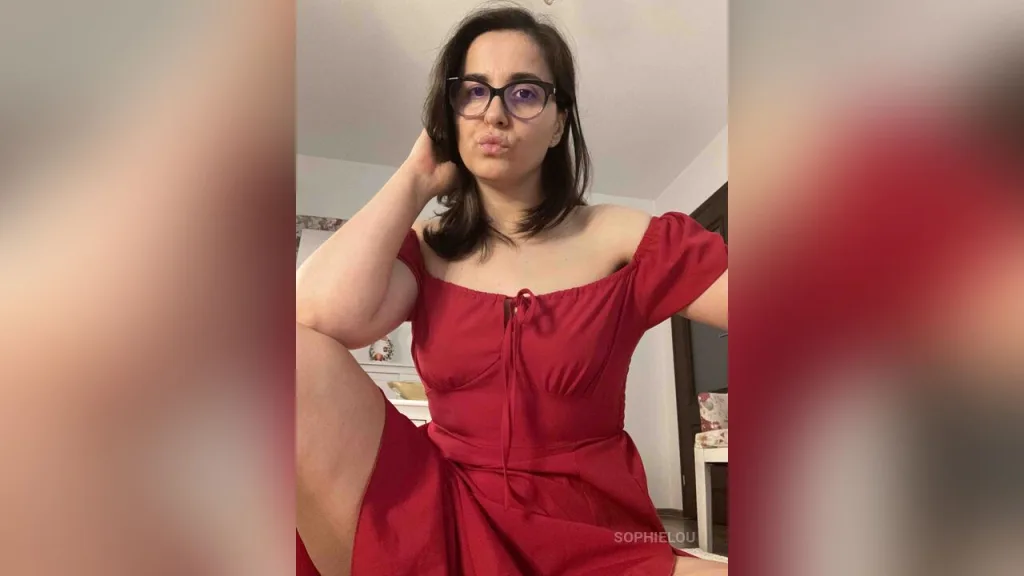 Woman in black floral off-the-shoulder top wearing glasses and relaxing at home with a thoughtful mood.