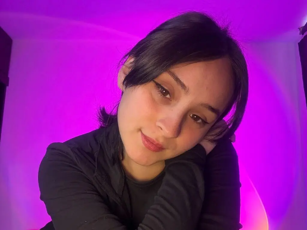 Young woman in a black turtleneck relaxing against a vibrant purple neon background with a moody glow.