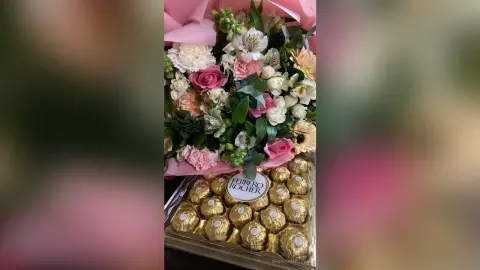 Elegant bouquet of pink roses and white flowers paired with a box of Ferrero Rocher chocolates for a romantic gift.
