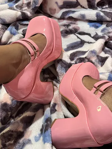 Pair of pink patent leather platform high heels on a soft leopard print faux fur blanket.