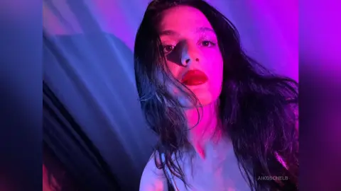 Young woman with red lipstick posing under moody pink and blue neon lighting.
