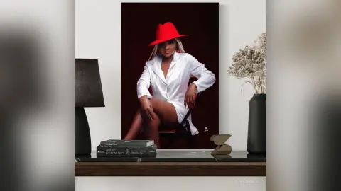 Elegant woman in a white shirt and red hat sitting in a stylishly lit modern living room setting.