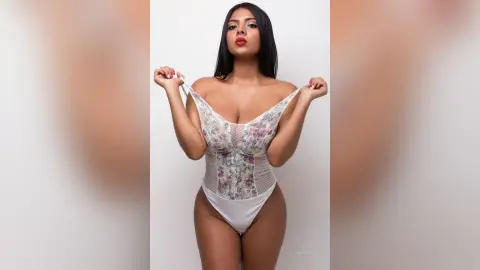 Anieminori poses in a white floral lace bodysuit, pulling at the straps with her long dark hair down.