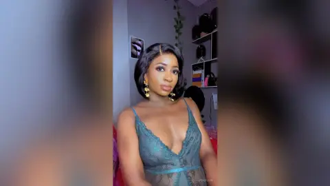 JoanJon poses in a low-cut teal lace bodysuit with her dark hair styled in a bob.