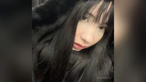 MarieJosePhilip poses with long, dark hair and blunt bangs, looking directly at the camera in a close-up shot.