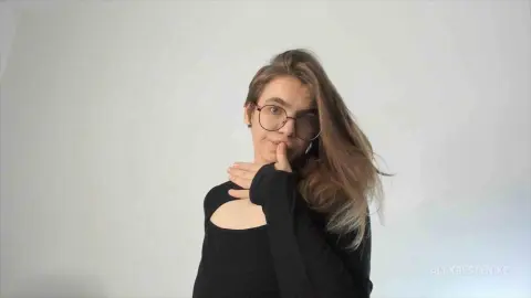 Young woman with glasses in a black long-sleeve top posing against a white background with a soft, calm mood.