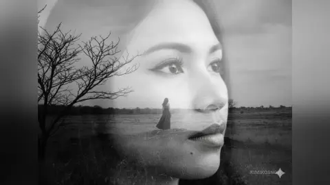 Double exposure black and white portrait of a woman's face overlaid with a lonely figure in a vast field.