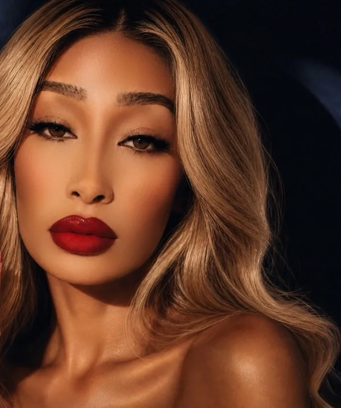 SOBLU — SOBLU poses with long blonde hair and bright red lipstick looking into the camera.