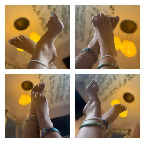 Lettie_Looner shows off her bare feet and ankles with white nail polish, wearing bracelets against a warm, lit background.