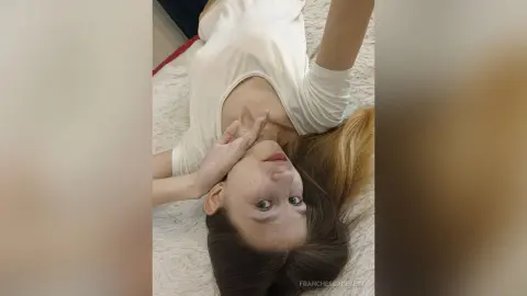 Young woman in a white t-shirt relaxing on a white textured surface with a peaceful mood.