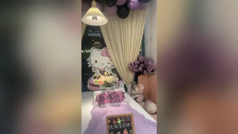 KireliaYan — KireliaYan sits behind a birthday cake and Hello Kitty decorations in a room with purple balloons and cream curtains.