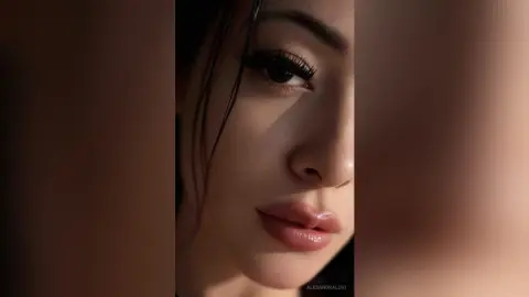 Close-up portrait of a woman with dramatic eye makeup and glossy lips in warm, moody sunlight.