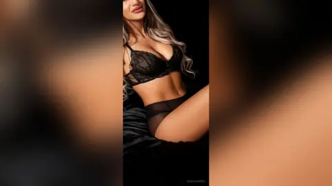 Glamorous woman in black lace lingerie posing against a dark background for a moody, elegant look.