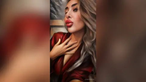 Glamorous woman in a red silk robe with long wavy hair posing for a moody, elegant portrait.