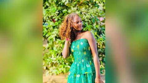 RemiNax — RemiNax poses outdoors in a green floral strapless dress with her long curly hair flowing over her shoulder.