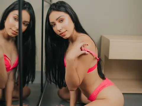 Beautiful woman in pink lace lingerie sitting in a modern room with a soft, moody aesthetic.