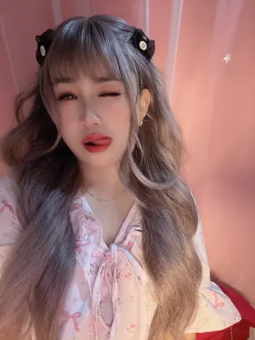 LavenderBae winks and sticks her tongue out while wearing a pink floral top and black hair clips.