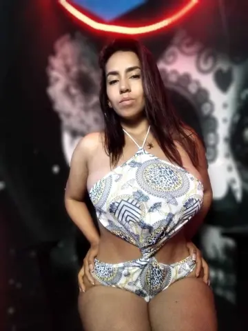 Woman in patterned white halter bikini posing confidently against a dark artistic background.