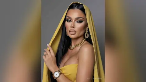 Glamorous woman in a yellow silk headscarf and gold jewelry posing with elegant makeup in a studio setting.