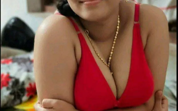SouthIndianCutie poses in a blue saree, showing her bare stomach and cleavage while leaning back against a light-colored surface.