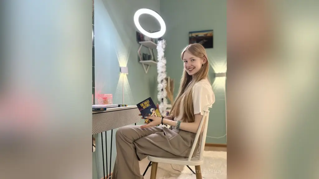 Blonde woman in a white t-shirt relaxing in a bright, cozy room with soft lighting.