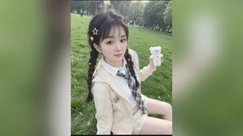 Young woman with braided hair and white outfit holding a teddy bear in a sunny green park.