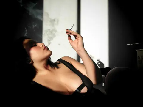 Moody portrait of a woman in a black top smoking a cigarette in dramatic low-light lighting.