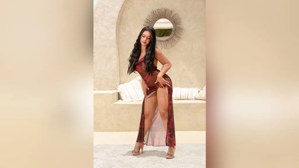 MeganneAllen — MeganneAllen poses in a sheer red patterned dress with high slits, showing her long dark hair and legs.