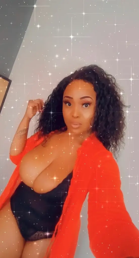HONEYROSEYX smiles while wearing a red bra that shows off her cleavage and bare shoulders.