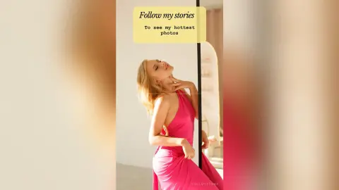 StellaFletcher poses with her hands behind her neck, wearing a pink halter-neck dress against a light background.